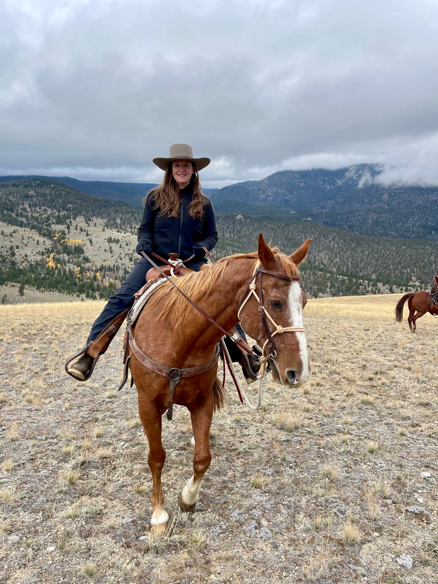 woman with hat riding a horse