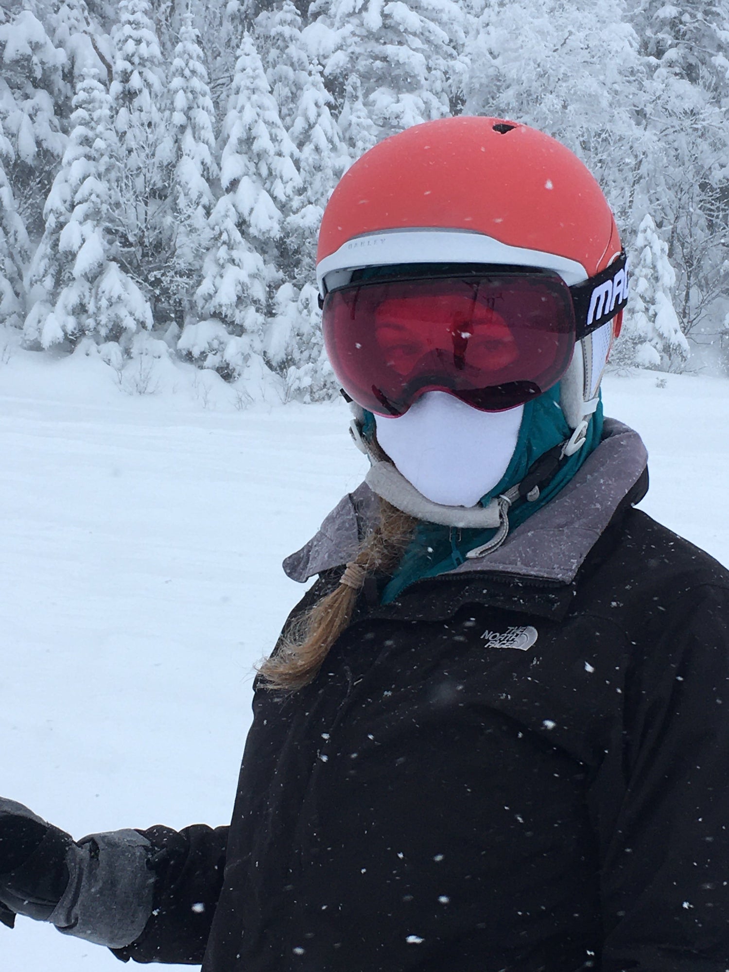 woman with ski goggles and helmet standing in the snow