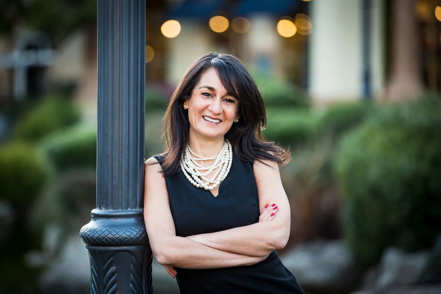 Tina Murphy standing with arms crossed outside leaning against a post